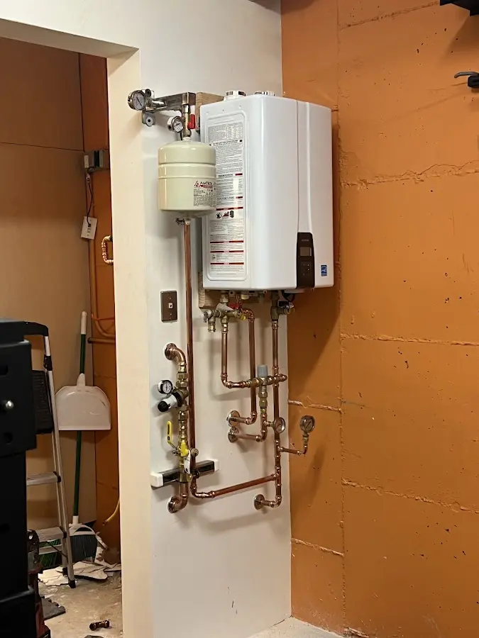 Plumbing technician inspecting water heater connections in Wrightsville